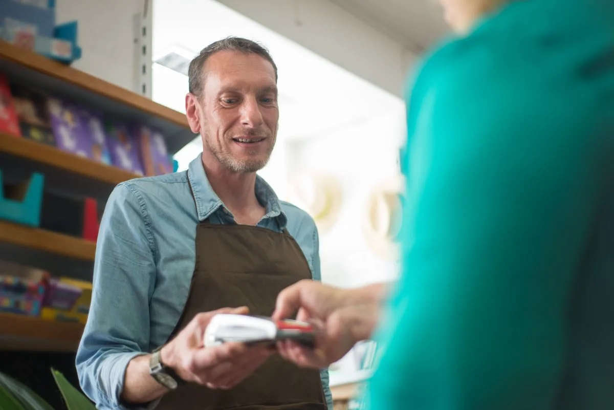 Commerçant accompagnant un client en magasin